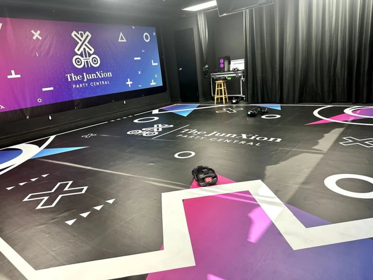 Interactive digital floor display with purple and blue graphics and a person in a dark room with large screen and desk