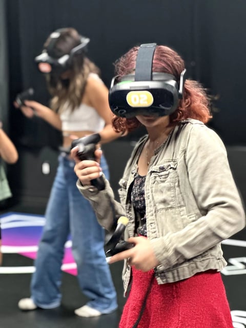 Woman wearing VR headset and holding controllers in a virtual reality experience space